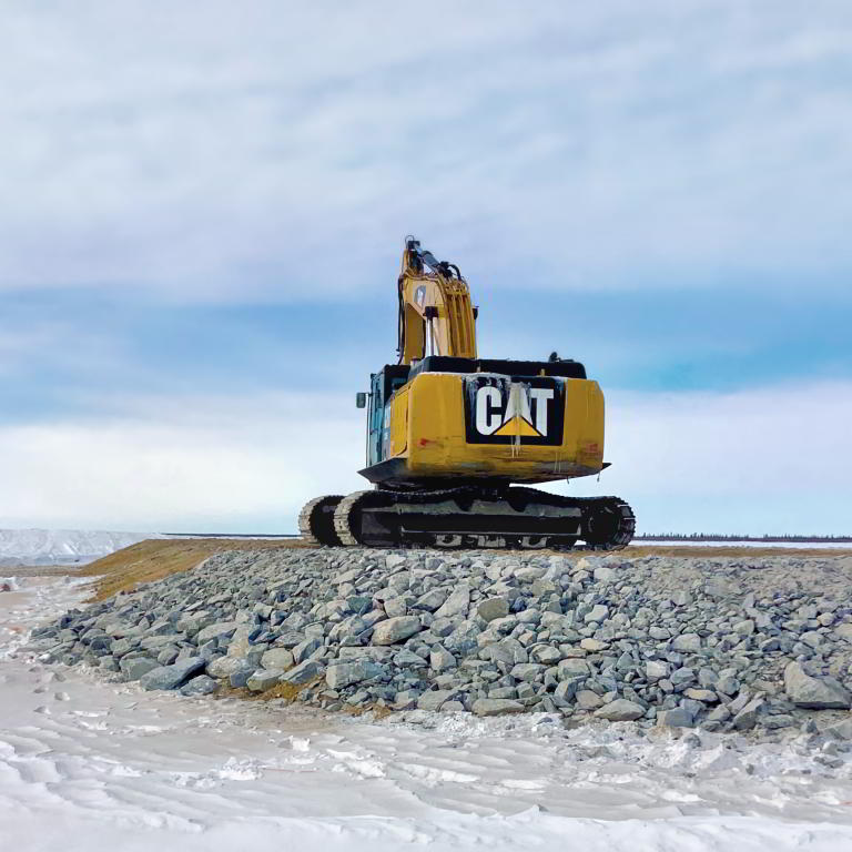 Caterpillar excavator on gravel mound